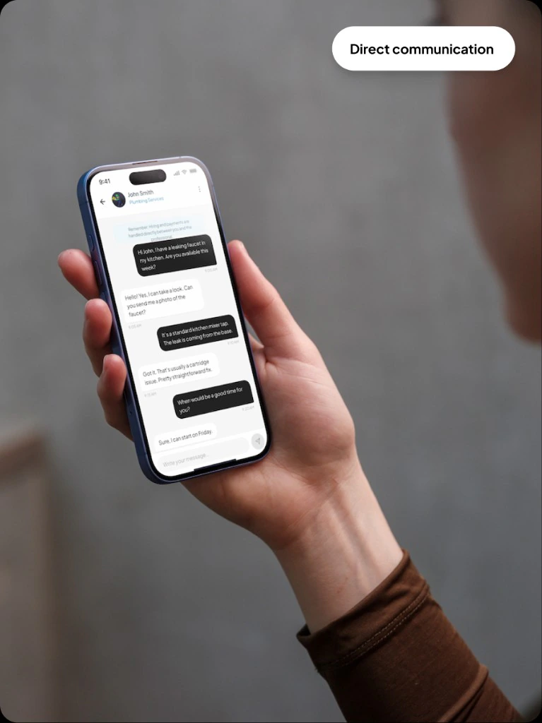 Hand holding phone showing chat interface